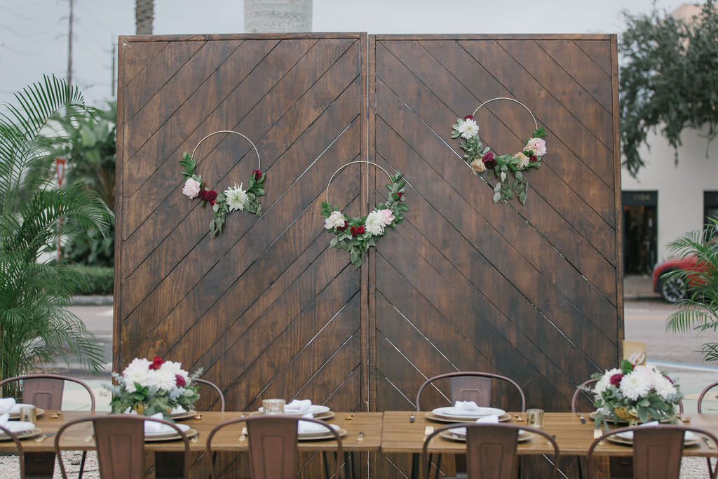 Open Air St. Pete Wedding Reception with Wooden Accent Wall with Floral Hoop Decor and Metal Chairs | Outdoor St. Pete Wedding Reception Venue Intermezzo