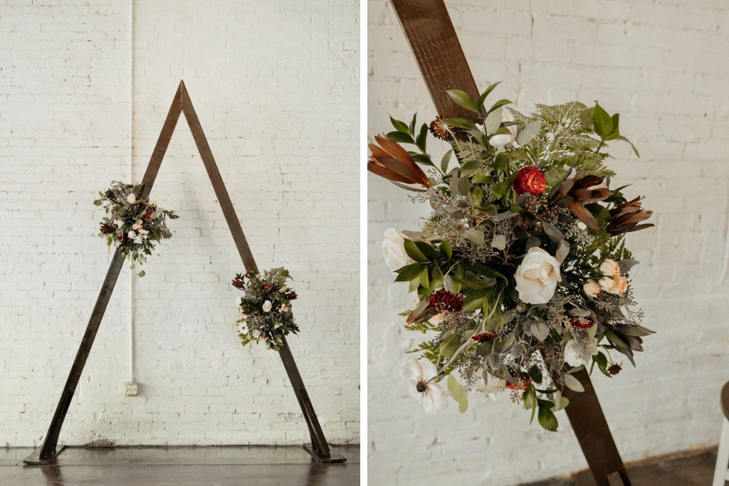 Dark and Moody Inspired Wedding Ceremony Decor, Triangle Arch with Dark Colored Ivory, and Greenery Floral Bouquets | Lakeland Industrial Modern Wedding Venue and Event Space Haus 820
