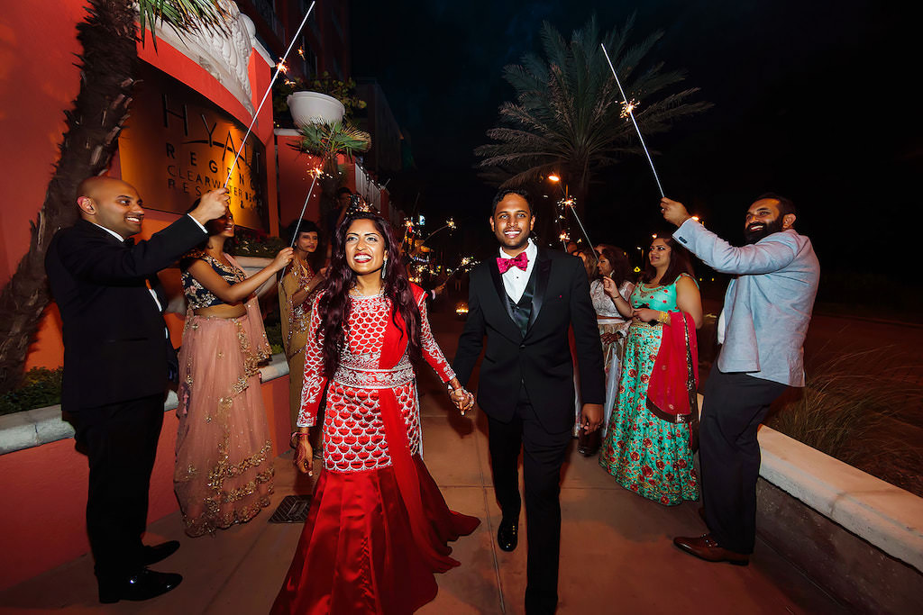 Traditional Indian Hindu Bride and Groom Nighttime Sparkler Wedding Reception Exit Portrait, Bride in Red and Silver Embellished Sari, Groom in Black Tuxedo