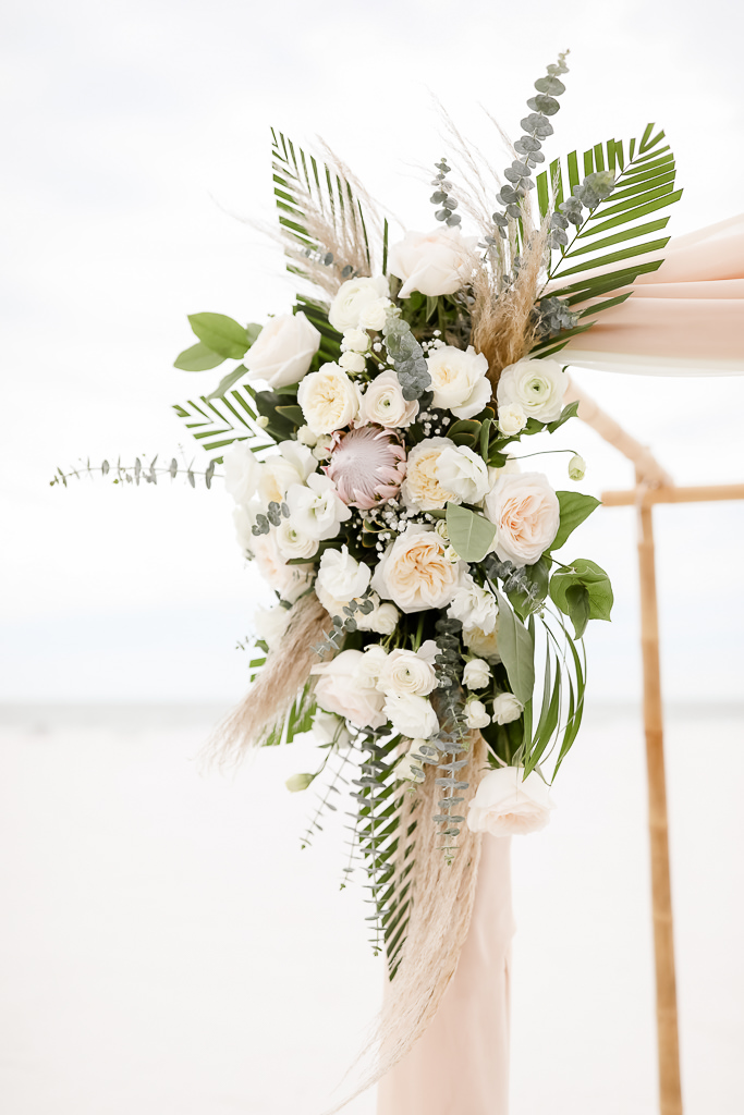 Tropical Beach Inspired Wedding Ceremony Decor, Ivory and Blush Pink Garden Roses, Silver Dollar Eucalyptus, Pink Protea Palm Leaf Floral Bouquet on Bamboo Ceremony Arch | Clearwater Beach Photographer Lifelong Photography Studios
