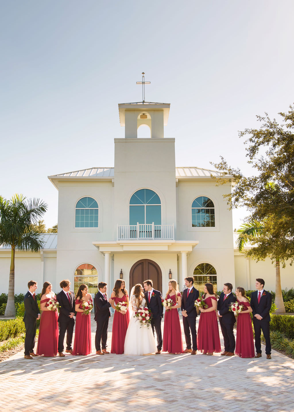 Tampa Bay Bride, Groom, Bridesmaids and Groomsmen Wedding Party Portrait, Bridesmaids in Long Red Dresses | Safety Harbor Wedding Ceremony Venue Harborside Chapel