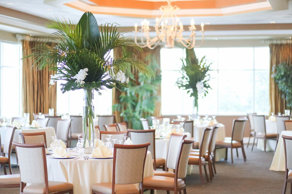 Tropical, Florida Beach Elegant Inspired Ballroom Wedding Reception Decor, Round Tables with Tall Glass Vase, White Florals and Palm Leaf Centerpiece | Photographer LifeLong Photography Studios | St. Pete Beach Waterfront Wedding Venue Isla Del Sol Yacht and Country Club