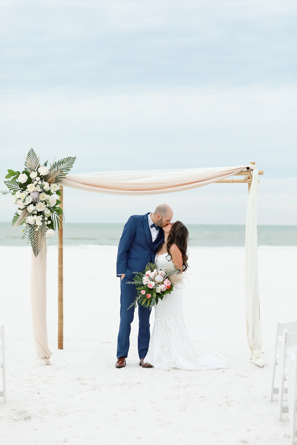 Bride and Groom Intimate Wedding Portrait on the Beach, Bamboo Bamboo Ceremony Arch with Tropical Inspired Floral Arrangement | Photographer Lifelong Photography Studios | Hilton Clearwater Beach