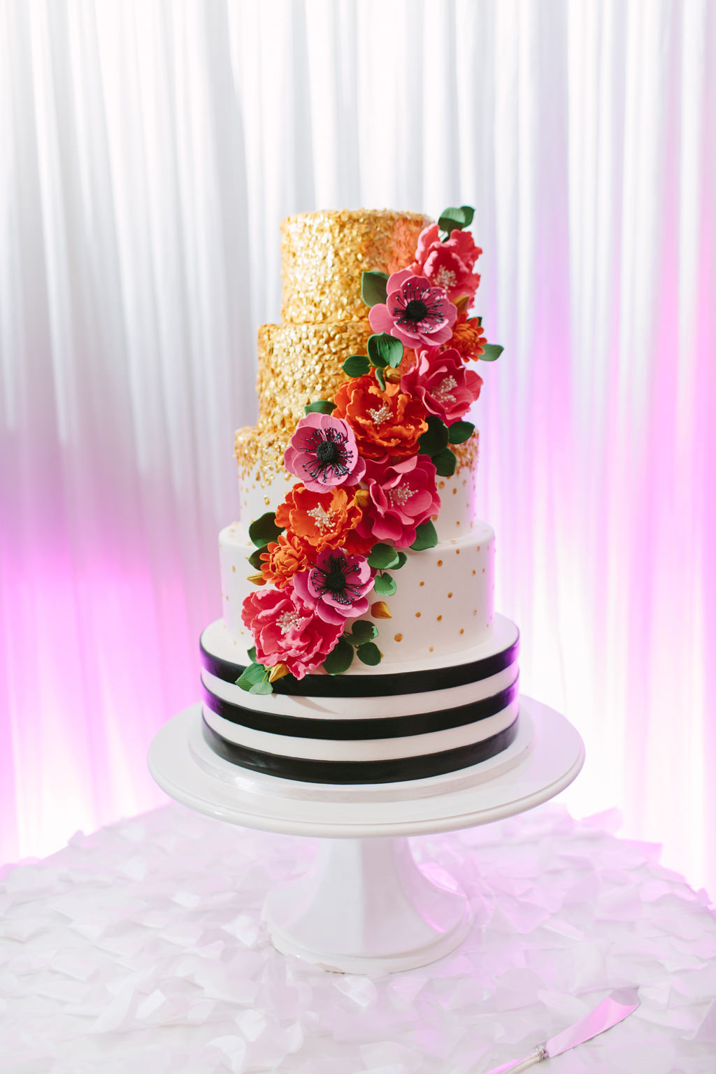 Whimsical Kate Spade Inspired Five Tier Wedding Cake, Black and White Stripe Tier, White and Gold Dotted Tier, Gold Painted Tiers, with Colorful Cascading Orange and Pink Flowers