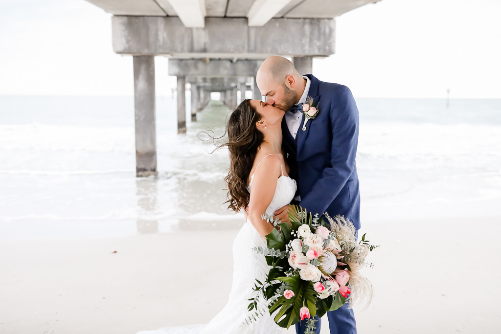 Tampa Bay Bride and Groom Beach Wedding Portrait, Carrying Blush Pink and White Floral Wedding Bouquet with Green Palm Leafs | Photographer Lifelong Photography Studios