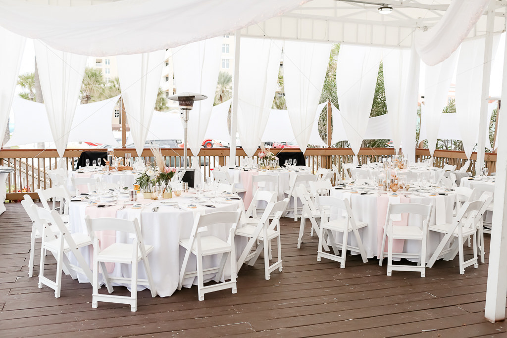 Outdoor Beach Deck Wedding Reception Decor, Round Tables, White Table Cloths, White Folding Chairs, Blush Runners, White Linen Drapery, Low Centerpieces | Photographer Lifelong Photography Studios | Hotel Wedding Venue The Hilton Clearwater Beach Resort & Spa