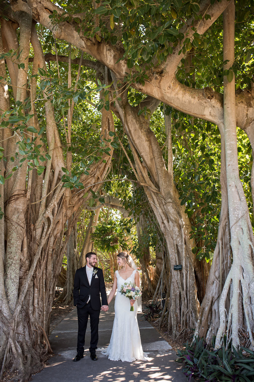 Florida Bride and Groom Holding Hands Under Banyan Trees | Sarasota Wedding Venue Marie Selby Botanical Gardens