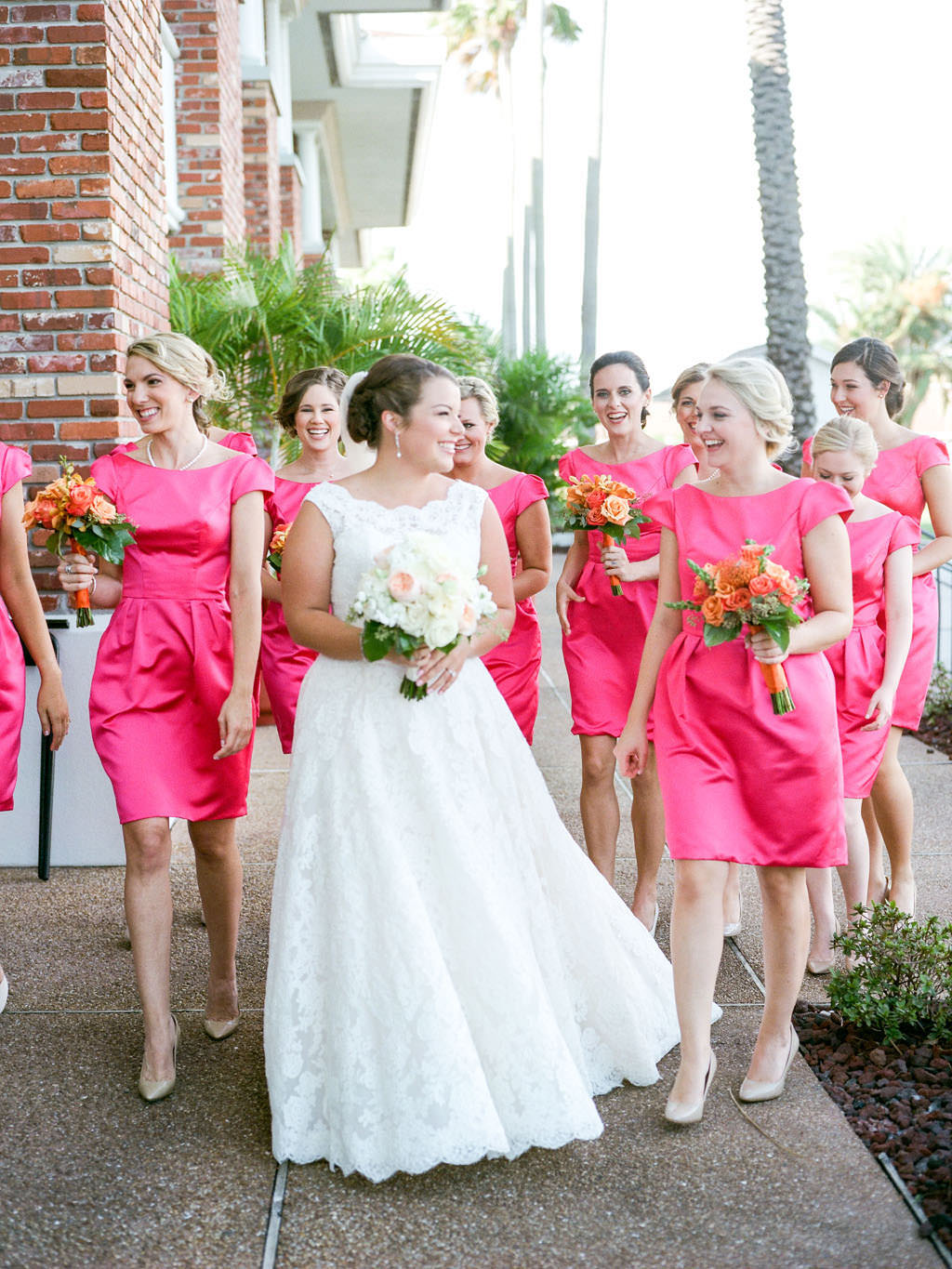 Kate Spade Inspired Wedding, Bride and Bridesmaids Wedding Portrait, Bridesmaids in Matching Short Bright Pink Dresses with Colorful Floral Bouquets, Bride in Lace A Line Off the Shoulder Neckline with White and Blush Pink Floral Bouquet