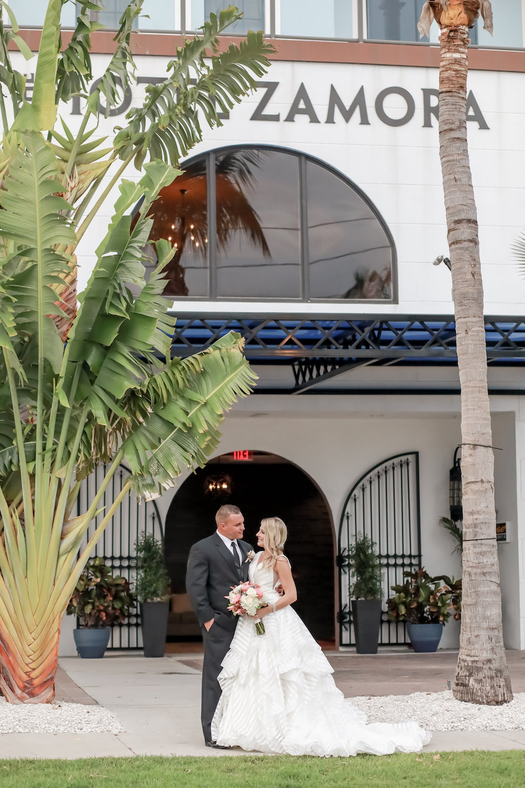 Florida Bride and Groom Wedding Portrait Out Front of St. Pete Beach Wedding Venue Hotel Zamora | Tampa Bay Wedding Photographer Lifelong Photography Studios | Wedding Dress Shop Truly Forever Bridal