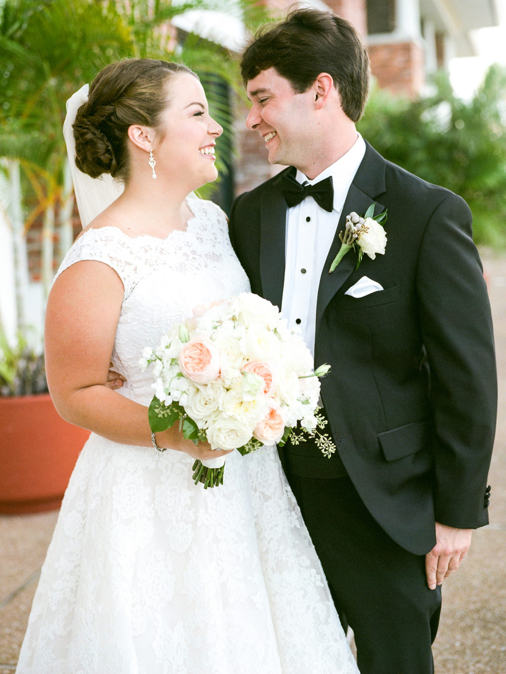 Florida Bride and Groom Wedding Portrait, Bride in Lace A Line Off the Shoulder Neckline Wedding Dress with White, Ivory and Blush Pink Floral Bouquet, Groom in Black Tuxedo