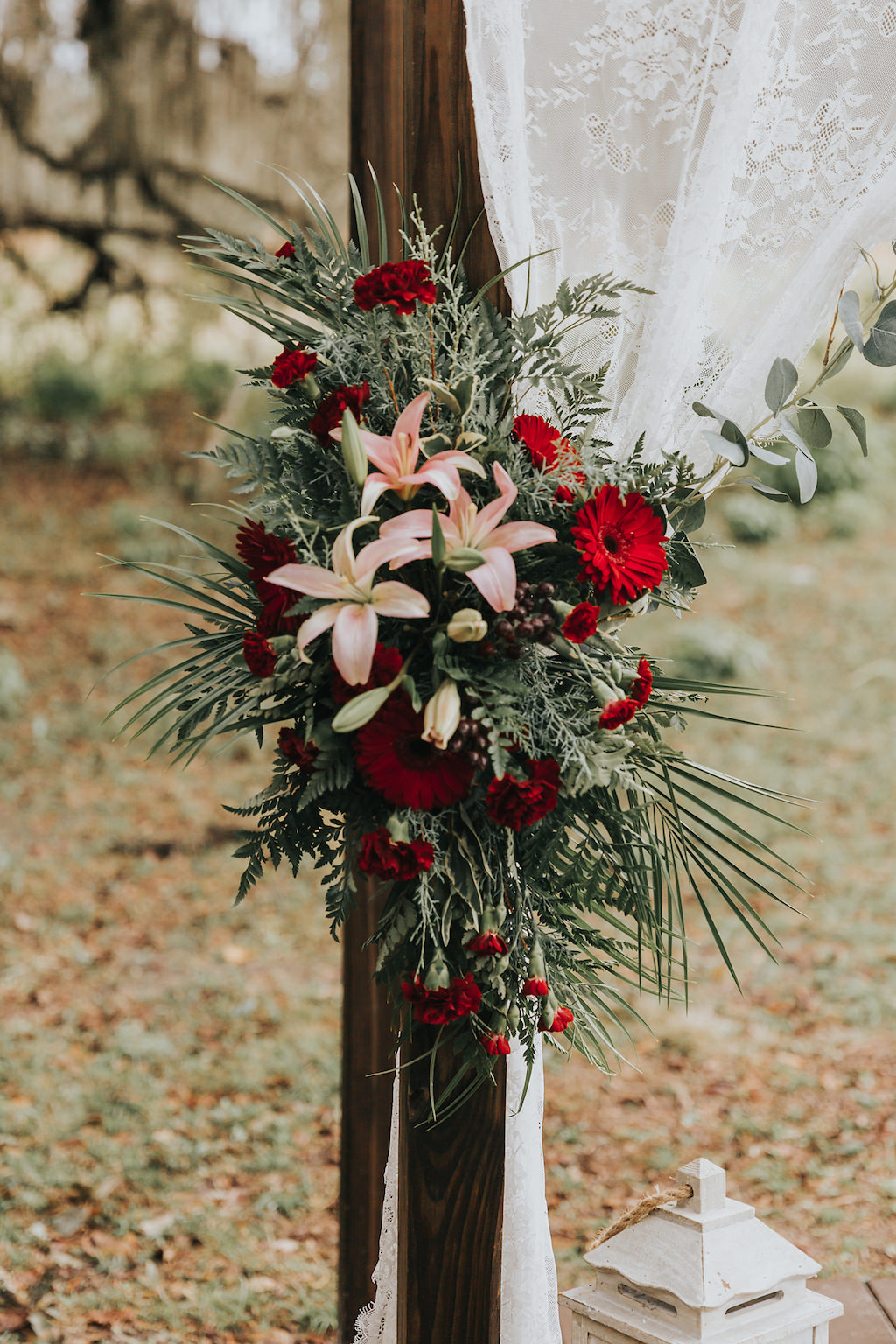 Rich Red and Blush Pink Floral Arrangement with Greenery Against Wooden Tampa Bay Ceremony Arch