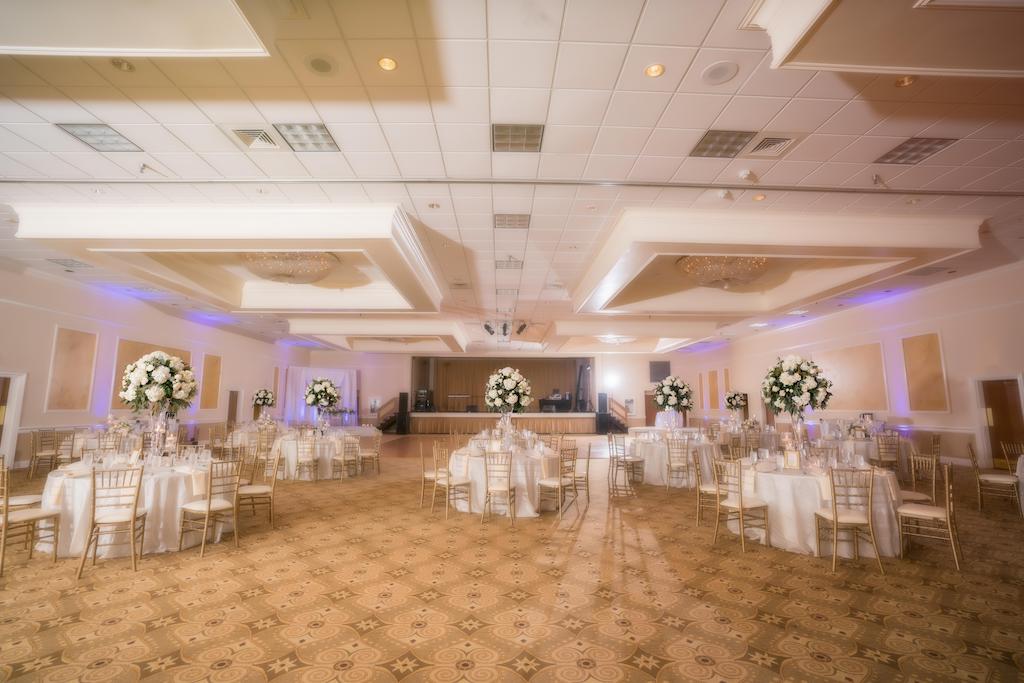 Elegant Wedding Decor at Ballroom Reception, Round Tables with White Lines, Gold Chairs, Tall Centerpieces with White Roses and Greenery | Tampa Bay Wedding Venue Innisbrook Golf & Spa Resort