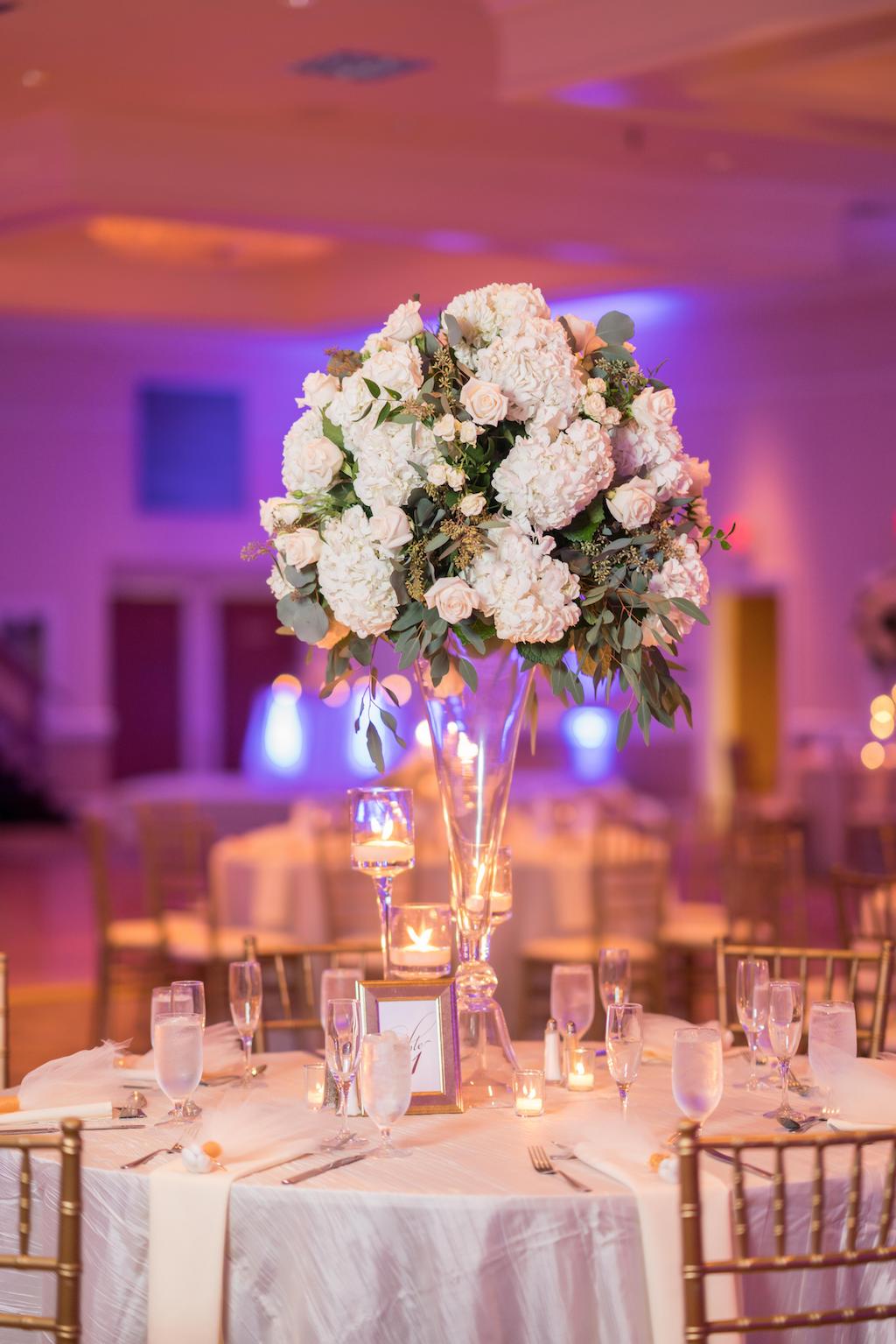 Elegant Wedding Decor at Ballroom Reception, Round Tables with White Lines, Gold Chairs, Tall Crystal Vase Centerpiece with White Flowers and Greenery, Clear Candle Votives | Tampa Bay Wedding Venue Innisbrook Golf & Spa Resort