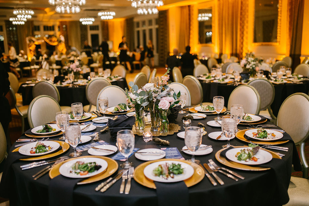 Elegant Classic Ballroom Wedding Reception Decor, Round Tables with Black Tablecloths, Gold Chargers, Low Glass Vases with Blush Pink Roses and Greenery Centerpieces | Downtown St. Pete Hotel Wedding Venue The Birchwood