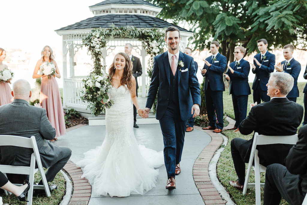 Florida Bride and Groom Just Married Recessional at Wedding Venue Davis Island Garden Club, Bride Carrying White and Green Floral Bouquet | Tampa Bay Florist Monarch Events and Design | Truly Forever Bridal