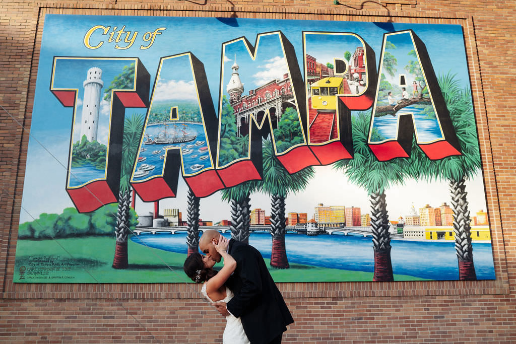 Florida Bride and Groom Wedding Portrait, Kissing In Front of Iconic City of Tampa Art Mural | Tampa Bay Wedding Photographer Grind & Press Photography