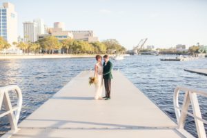 Bride and Groom Romantic Wedding Portraits at Outdoor Waterfront Wedding Venue Tampa River Center in Downtown Tampa , Groom in Elegant Emerald Velvet Jacket with Velvet Green Shoes, Bride in Ivory and Gold Wedding Dress, Carrying Colorful Bouquet | Tampa Bay Wedding Photographer Andi Diamond Photography | Tampa Bay Florist Apple Blossoms Floral Designs