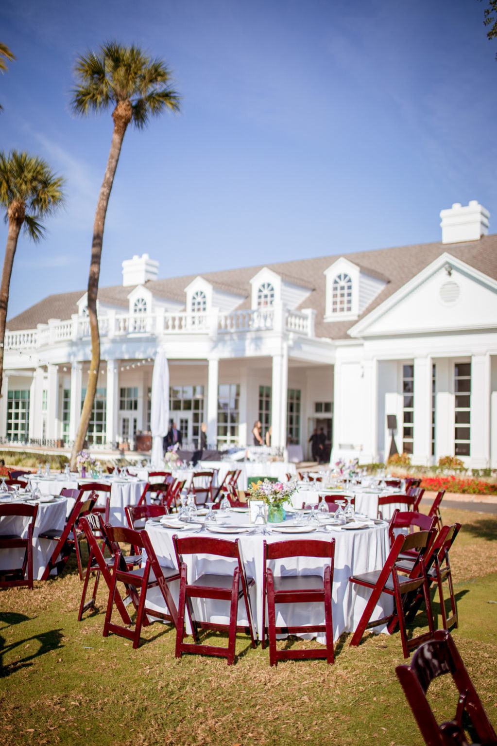 Rustic Southern Chic Garden Wedding Decor in Backyard Reception in South Tampa, White Round Tables with Wooden Folding Chairs, Colorful Centerpieces, at Palma Ceia Golf & Country Club | Tampa Bay Wedding Planner Jessie Soplinski with Breezin' Weddings