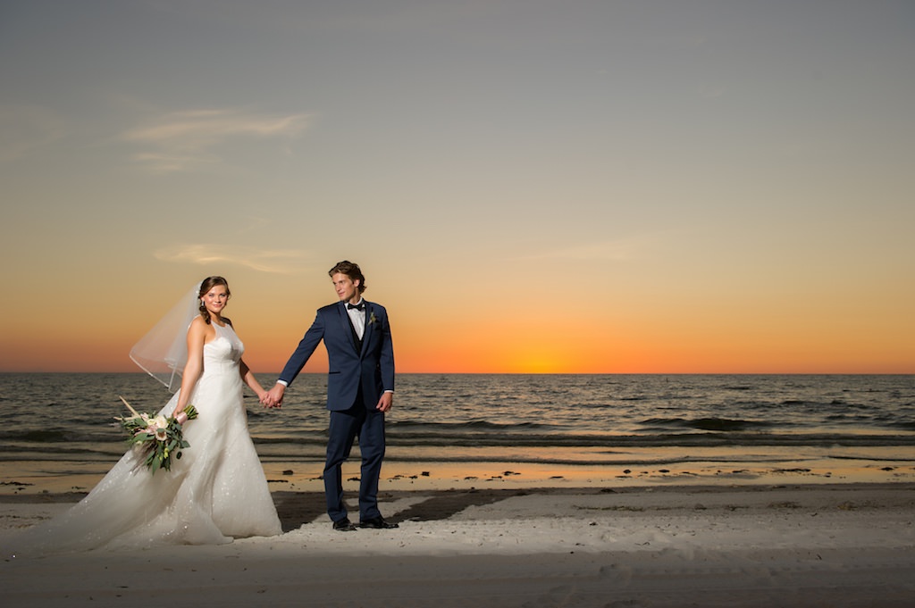Florida Bride and Groom Wedding Portrait at Sunset on St. Pete Beach, Bride in Soft White A-line Wedding Dress With Sheer Top, Tulle Veil, Carrying Bohemian Inspired Floral Wedding Bouquet | St. Petersburg Beach Resort and Hotel Wedding Venue The Don Cesar | Tampa Bay Wedding Photographer Andi Diamond Photography | | Tampa Wedding Dress Shop Truly Forever Bridal