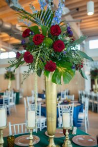 Elegant and Eclectic Jewel Toned Themed Reception Wedding Decor, Large Gold Vase Centerpieces with Overflowing Green Purple and Blue Florals with Red Roses Arrangements | Silk and Velvet Jewel Tone Tablecloths, Gold Charger, Tall Silver Candelabras | Tampa Bay Wedding Photographer Andi Diamond Photography