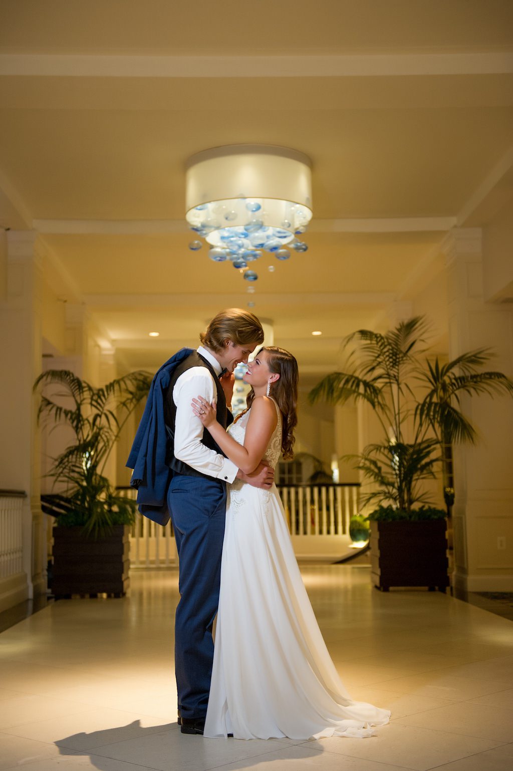 Tampa Bay Bride and Groom Wedding Portrait in Chic Hotel Lobby, Bride in Streamline Flowy Reception Gown | Tampa Wedding Dress Shop Truly Forever Bridal | Tampa Bay Wedding Photographer Andi Diamond Photography