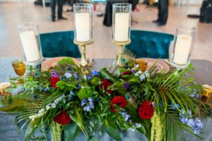 Elegant and Eclectic Jewel Toned Themed Reception Wedding Decor, Green Purple Red and Blue Floral Arrangements with Peacock Feathers, Velvet Emerald Sweetheart Tablecloth and Emerald Velvet Chairs, Gold Chargers, Silver Candelabras | Tampa Bay Wedding Photographer Andi Diamond Photography