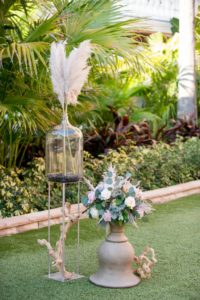 Bohemian Outdoor Wedding Decor, Neutral Color Pampas Grass In Oversized Glass Water Jug On Top Of Natural Wooden Decor, Multi-colored and Textural Bohemian Floral Arrangement with Silver Dollar Eucalyptus Greenery, Garden Roses and Protea | St. Pete Beach Resort and Hotel Wedding Venue The Don Cesar | Tampa Bay Wedding Photographer Andi Diamond Photography | Tampa Bay Wedding Planner UNIQUE Weddings + Events