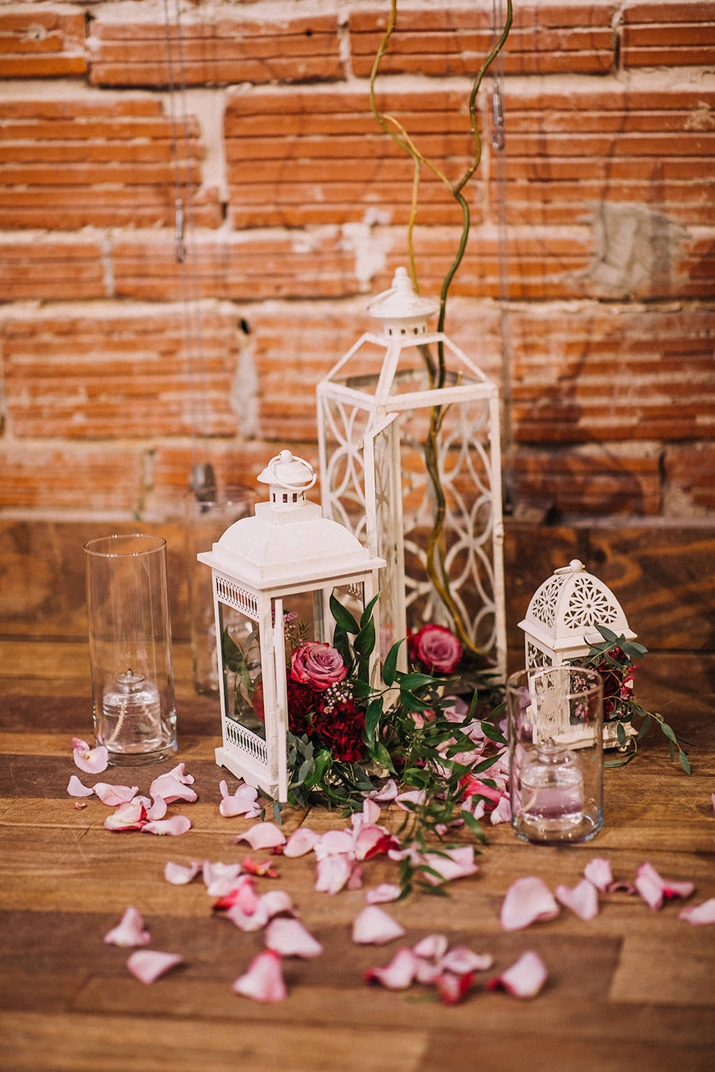Romantic Vintage White Lanterns with Red Roses and Glass Liquid Candles Wedding Ceremony Decor, in front of Red Exposed Brick Wall | Downtown St. Pete Wedding Venue NOVA 535