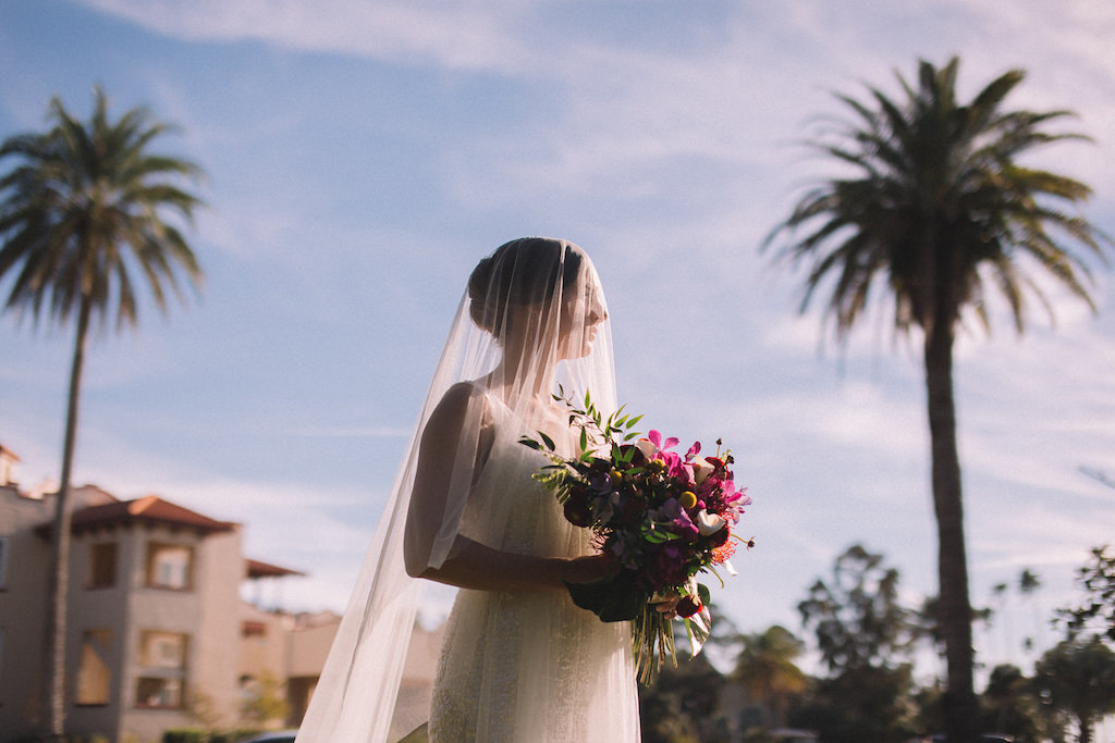 Clearwater Bride Wearing Sleeveless White Sequin Sheath Wedding Dress with Long Tulle Veil, Carrying Tropical Inspired Wedding Bouquet with Colorful Florals and Greenery | Tampa Bay Boutique Hotel Wedding Venue Fenway Hotel