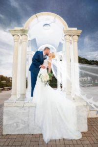 Tampa Bride and Groom Intimate Wedding Portrait, Bride Wearing Pronovias White Lace Wedding Dress With Cathedral Length Train and Veil | Tampa Bay Bridal Dress Shop Nikki and Glitz Glam Boutique