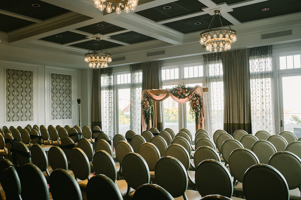 Indoor Ballroom Wedding Ceremony Decor, Wooden Arch with Blush Pink Draping, Colorful Flower Bouquets and Green Chairs | Downtown St. Pete Wedding Hotel Venue The Birchwood