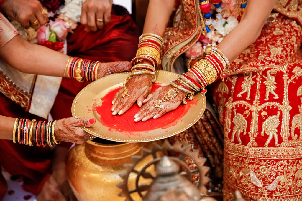 Indian Bride Performing Traditional Ritual For Wedding Ceremony, Henna Tattoo Hands on Gold Plate with Red Paint, Extravagant Bridal Jewelry
