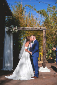 Tampa Bay Bride and Groom First Kiss under Wooden Ceremony Arch in Downtown St. Pete Bamboo Garden | Florida Unique Wedding Venue NOVA 535