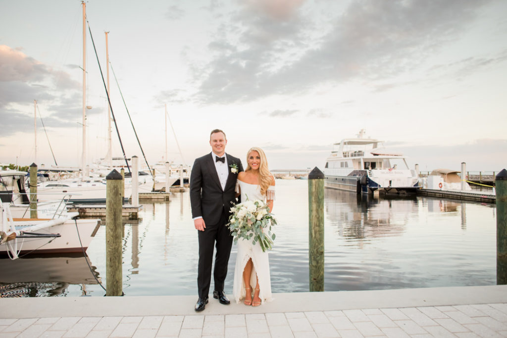 South Tampa Florida Bride Holding Organic White, Ivory, Blush Pink Floral and Greenery Bouquet and Groom on Waterfront Boat Dock During Sunset | Wedding Venue Tampa Yacht and Country Club | Tampa Bay Wedding Hair and Makeup Artist LDM Beauty Group