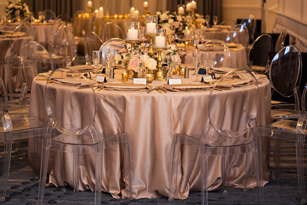 Romantic Glamorous Garden Inspired Wedding Decor, Blush Pink Table Linens, Ghost Clear Acrylic Chairs, Low Floral Centerpieces with White and Pink Roses, Gold Candelabras with Glass Votives | Historic St. Pete Beach Hotel The Don Cesar | Over The Top Rentals | Tampa Bay Florist Bruce Wayne Florals | Florida Wedding Planner Parties A La Carte | A Chair Affair