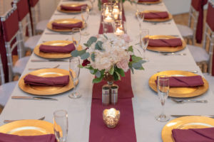 Long Feasting Table with Gold Chargers, Silver Chiavari Chairs, Burgundy Linens, Low White Floral Centerpiece with Blush Pink and Red Flowers | Brooksville Golf Course Southern Hills Plantation