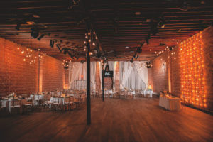 Romantic Indoor Wedding Reception with Exposed Brick Wall and String Lighting, Chiavari Chairs | Industrial Downtown St. Pete Wedding Venue NOVA 535