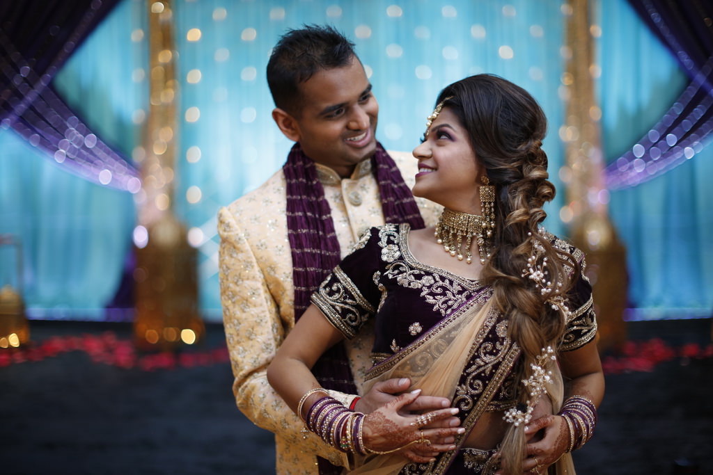 Traditional Indian Bride and Groom Wedding Portrait, Bride in Dark Purple and Gold Sari with Gold Sash and Extravagant Gold Bridal Jewelry and Accessories | Tampa Bay Wedding Hair and Makeup Michele Renee the Studio