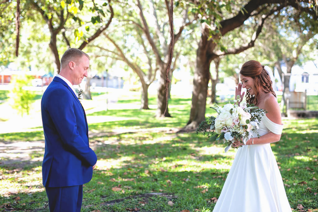 Tampa Bay Bride and Groom First Look in Straub Park, Downtown St. Pete, Bride Carrying Romantic White, Ivory, Blush Pink Floral Bouquet with Greenery