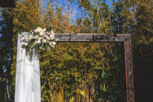 Downtown St. Pete Bamboo Garden Wedding Decor, Wooden Ceremony Arch with Romantic Floral Arrangement, Blush Pink, Ivory and White Flowers, with Greenery, White Draping | Tampa Bay Wedding Venue NOVA 535
