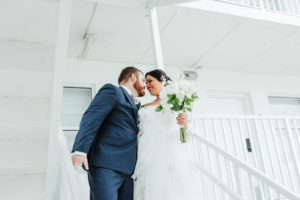 Artistic, Unique, Creative Florida Bride and Groom Wedding Portrait with All White Background, Carrying Traditional Round White Floral Bouquet with Greenery | Tampa Bay Boutique Hotel and Wedding Venue The Hotel Alba in Westshore