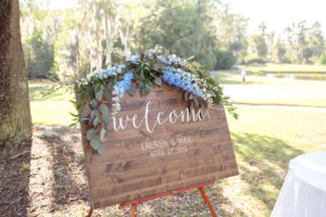 Rustic Classy Outdoor Wedding Ceremony Decor, Wooden Welcome Sign with Blue, White and Greenery Flowers | Tampa Bay Wedding Photographer Kristen Marie Photography