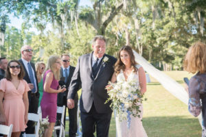 Florida Bride and Father Walking Down the Aisle Wedding Ceremony Portrait, Bride in Mikaella Lace Wedding Dress with Capsleeves, Plunging V Neckline and Rhinestone Crystal Belt Holding White, Ivory, Blue and Greenery Flower Bridal Bouquet | Tampa Bay Wedding Photographer Kristen Marie Photography | Innisbrook Golf & Spa Resort Wedding Venue