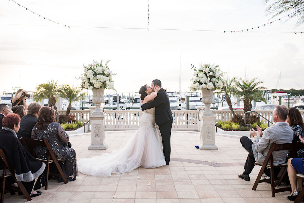 Florida Bride and Groom Exchanging First Kiss During Wedding Ceremony Portrait | Waterfront Tampa Bay Wedding Venue Westshore Yacht Club