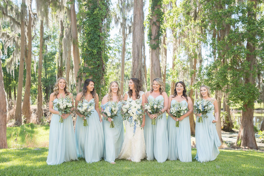 Palm Harbor Bride and Bridesmaids Outdoor Portrait, Bridesmaids in Flowy Classic Boho Long Powder Blue Dresses Holding White, Ivory, and Greenery Floral Bouquets | Tampa Bay Kristen Marie Photography | Innisbrook Golf & Spa Resort Wedding Venue | Destiny and Light Hair and Makeup Group | Bridesmaid Dress Shop Nikki's Glitz and Glam