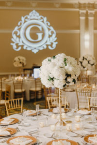 Traditional Classic Ballroom Wedding Reception Decor, Round Tables with White Tablecloths, Gold Chargers, Tall Gold Vase with Round White Floral Centerpiece, Custom Gobo Monogram Projection | St. Pete Hotel Ballroom Wedding Venue The Vinoy Renaissance