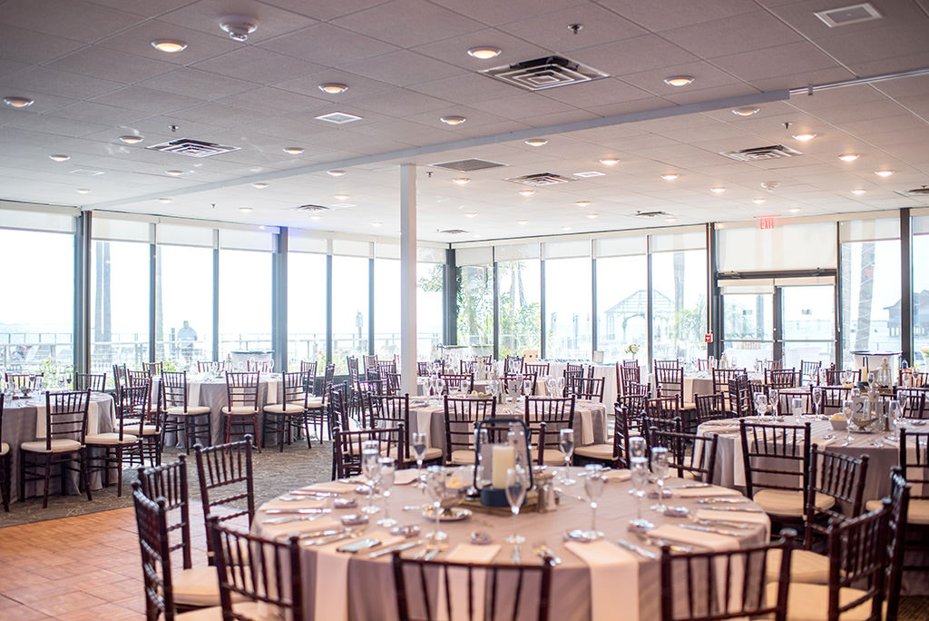 Nautical Inspired Wedding Reception Decor, Chiavari Chairs, Round Tables with Gray Linens, Low Centerpieces with Navy Candle Lanterns, Natural Lighting | | Tampa Bay Hotel and Wedding Venue The Godfrey Hotel & Cabanas