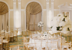 Classic, Timeless Traditional Ballroom Wedding Reception Decor, Round Tables with White Tablecloths, Gold Chiavari Chairs, Tall Gold Vases with Round White Floral Centerpieces | Luxurious St. Pete Hotel Ballroom Wedding Venue The Vinoy Renaissance