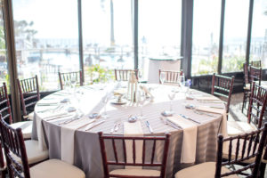 Nautical Inspired Wedding Reception Decor, Brown Chiavari Chairs, Round Tables with Gray Linens, Low Centerpieces with White Lighthouse, Natural Lighting | | Tampa Bay Hotel and Wedding Venue The Godfrey Hotel & Cabanas