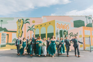 Modern, Unique Florida Bride and Groom Wedding Party Portrait, Bridesmaids in Long Dark Green Mix and Match Dresses, Downtown St. Pete Art Mural J&S Signs | Tampa Bay Photographer Kera Photography
